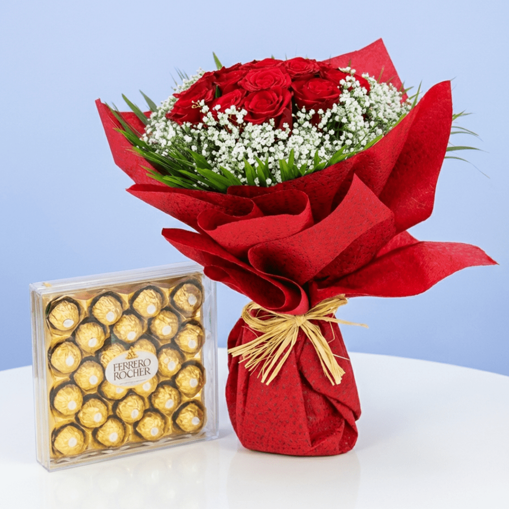 A bouquet of red roses and white baby's breath next to a box of Ferrero Rocher chocolates