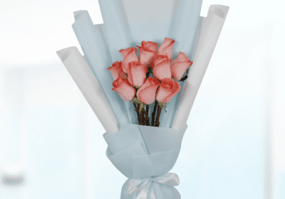 A vibrant bouquet of orange roses arranged elegantly, showcasing their lush petals and green foliage.