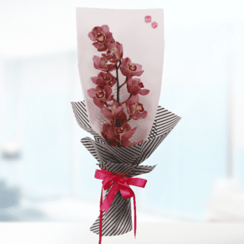 A bouquet of white cymbidium orchids featuring large, elegant red blooms, showcasing their beauty and long-lasting nature.