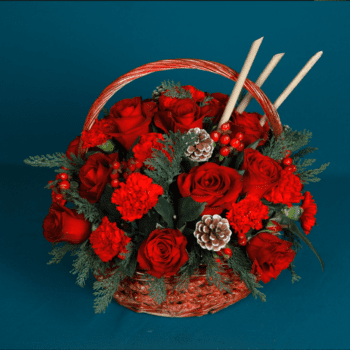 A basket filled with roses, carnations, and hypericum berries, adorned with luxury Christmas foliage and various decorative elements.