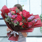girl holding a maroon hydrangia bouquet black tulip flowers florist near me