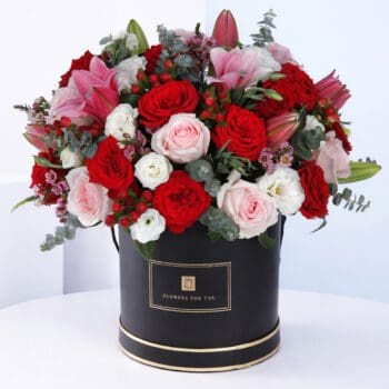 A vibrant arrangement of red roses and pink lilies, perfect for brightening up an office or home space.