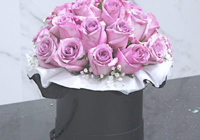 A special arrangement of purple roses in a decorative box, perfect for any occasion.