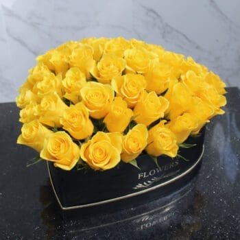 A box filled with vibrant yellow heart-shaped roses, elegantly arranged for a cheerful floral display.