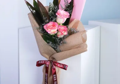 A trio of elegant roses in soft hues, arranged beautifully in a delicate bouquet, showcasing their natural beauty.