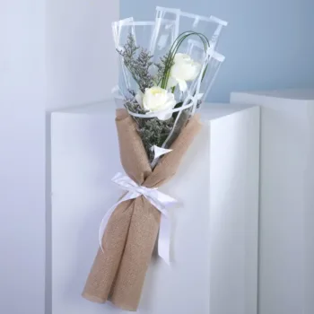 A bouquet featuring three stems of Sovereign Roses with Caspia leaves, showcasing elegant double white blooms.