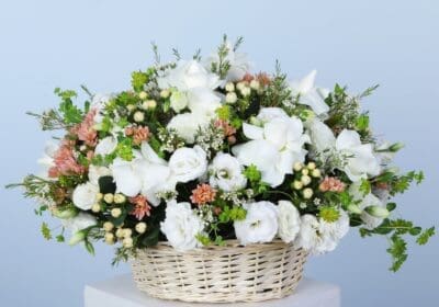 An exquisite collection of white flowers in a basket artistically arranged and underscoring elegance and floral charm.