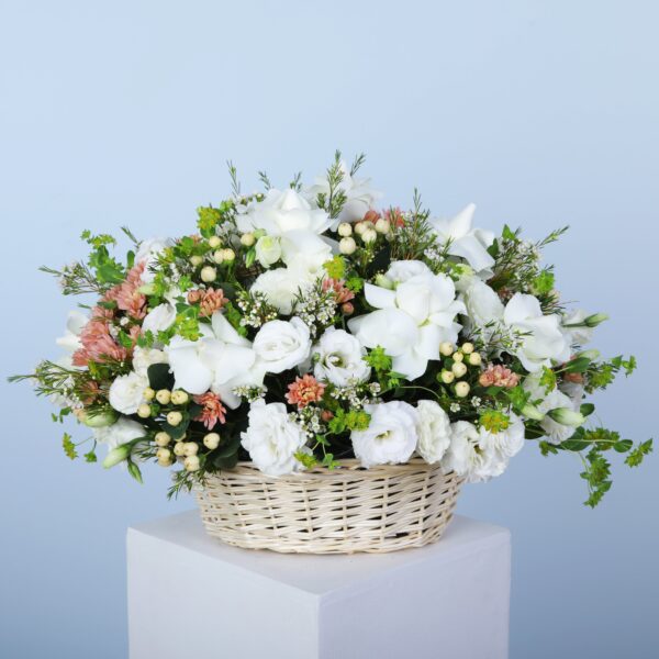 An exquisite collection of white flowers in a basket artistically arranged and underscoring elegance and floral charm.