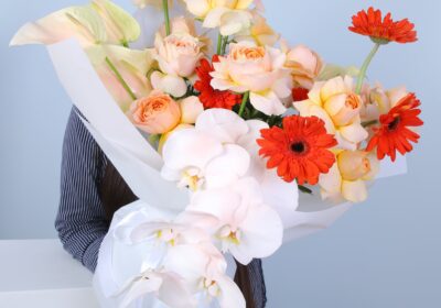 A person joyfully holds a bouquet of flowers, showcasing a colorful assortment of blossoms.