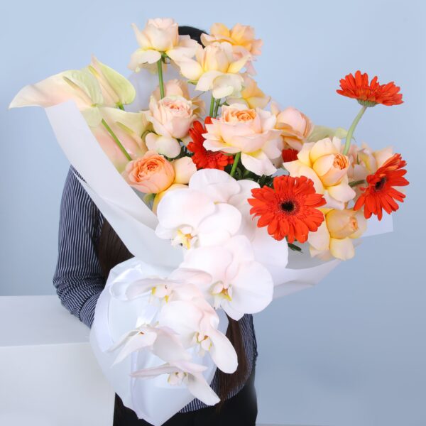 A person joyfully holds a bouquet of flowers, showcasing a colorful assortment of blossoms.