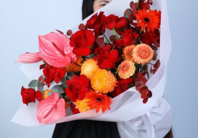 Vibrant Bouquet with Deco Painted, Explorer, Mini Gerbera, and Anthurium flowers accented by painted Eucalyptus.