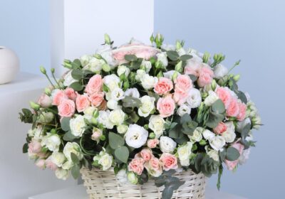 Pastel bloom flower basket with soft pink sweet sara roses, white spray roses, lisianthus, and eucalyptus stems.