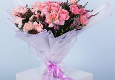 A bouquet featuring peach harmony roses, veronica stems, and colourful African flowers in an elegant arrangement.