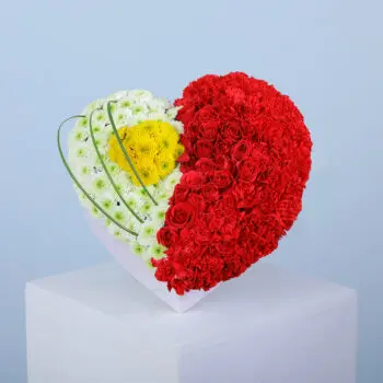 A heart-shaped floral arrangement divided into two sections, one with white chrysanthemums and the other with red carnations.