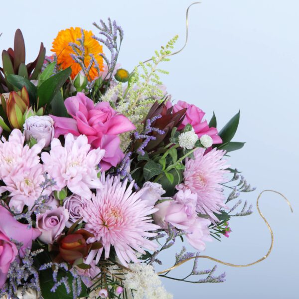 An elegant basket overflowing with colourful flowers, beautifully presented on a pedestal to showcase its charm.