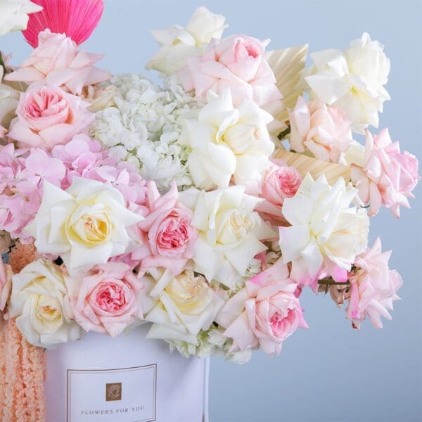 An exquisite flower box with white hydrangeas, pink Ohara roses, and dry leaves, perfect for special occasions or elegant gifts.