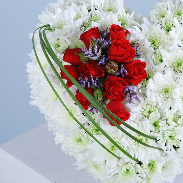 A heart-shaped bouquet of red and white flowers, symbolizing love—perfect for weddings or engagements.