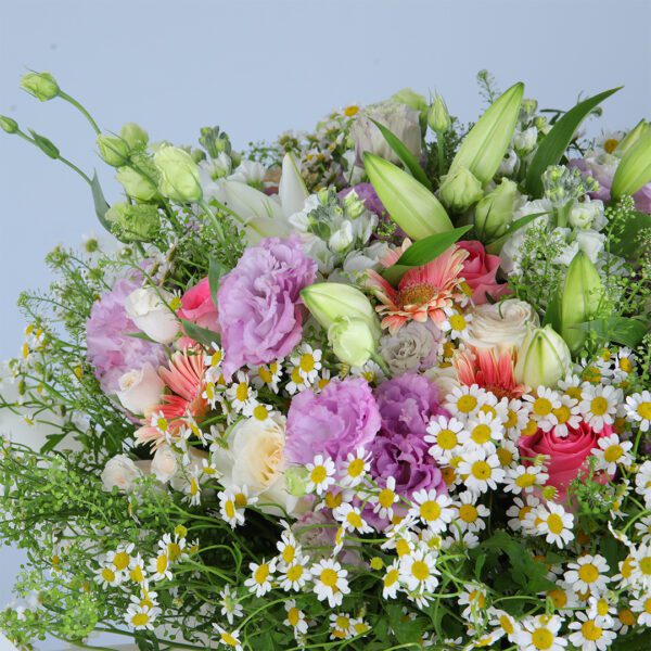 A stunning bouquet of pink and white flowers, including gerberas, roses, lilies, and other varieties.