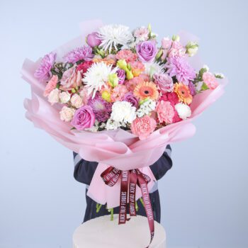 A close-up view of a hand tied bouquet showcasing pink hydrangea and mixed flowers