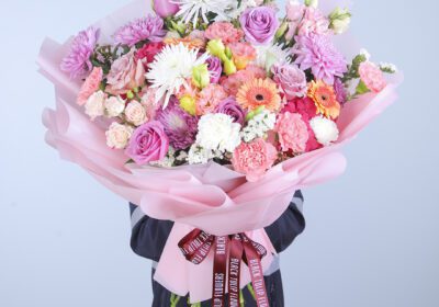 A close-up view of a hand tied bouquet showcasing pink hydrangea and mixed flowers