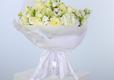 Elegant white blooms beautifully arranged in a bouquet with white wrap.