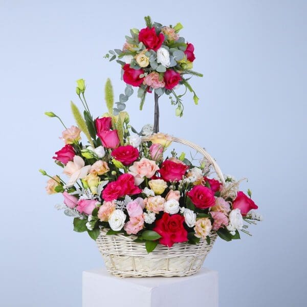 A colorful basket of various shades of roses, featuring a small rose tree and cascading blooms.