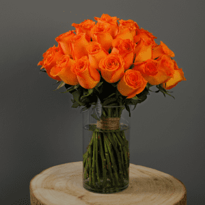 The image shows a stunning bouquet of orange roses arranged in a clear glass vase.