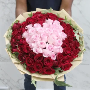 The image shows a large and impressive bouquet of roses held by a person. The bouquet features a beautiful arrangement