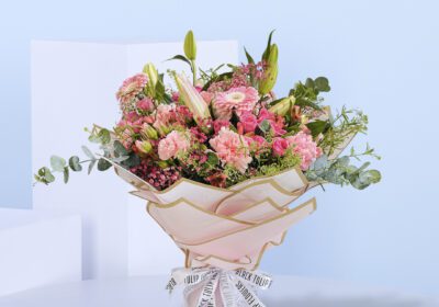 A beautiful bouquet of pink flowers tied up with a white ribbon.
