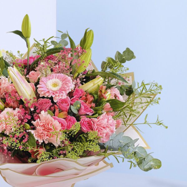 A beautiful bouquet of pink flowers tied up with a white ribbon.