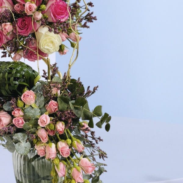 2 Twilight Rose Cascade Beautiful flower arrangement featuring vibrant pink roses and lush greenery with decorative accents.