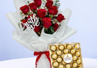 Stunning bouquet of a dozen red roses alongside a box of Ferrero chocolates, perfect for a romantic gesture.