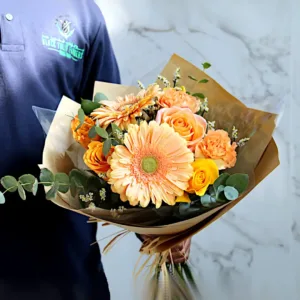 Orange roses and gerberas bouquet in brown paper wrap