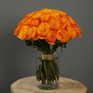 Orange roses in a clear glass vase.