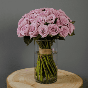 Lavender roses in a clear glass vase.