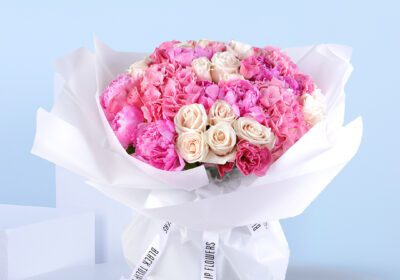Pink and white floral bouquet wrapped in white with an "Eid Mubarak" topper.