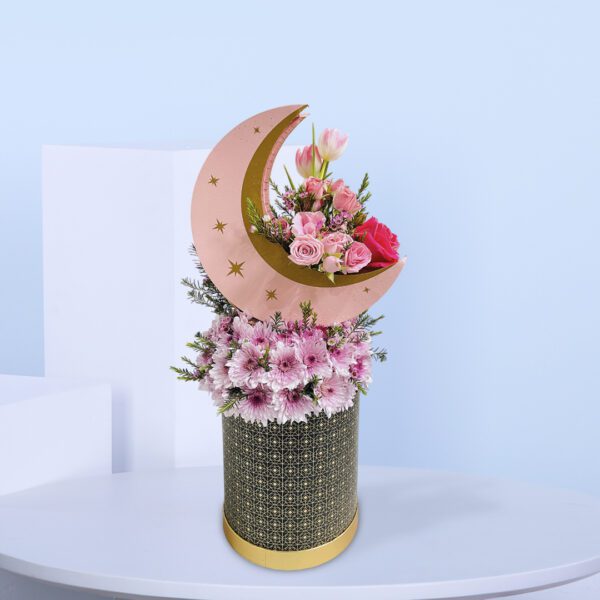 Pink roses, tulips, and daisies in a crescent moon floral design