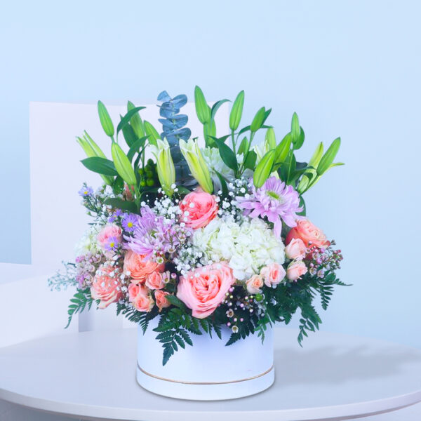 A white box containing an assortment of blooming flowers, creating a cheerful and decorative display.