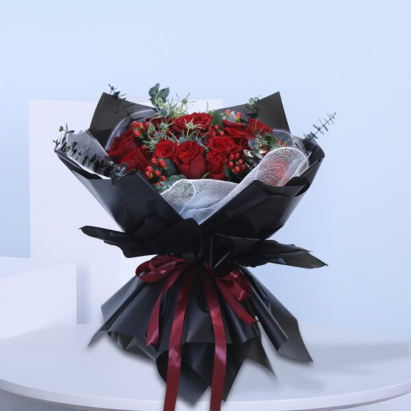 Romantic red roses in a dark wrapped bouquet, perfect for a special occasion.