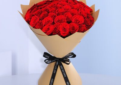 Large red roses are elegeantlly arranged in a big bouquet.