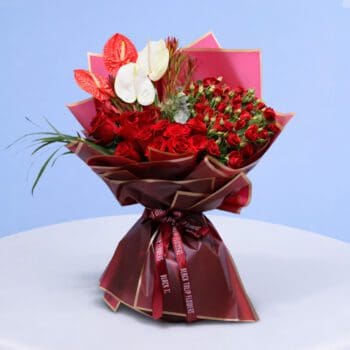 Bright and cheerful bouquet with red roses and white anthuriums.