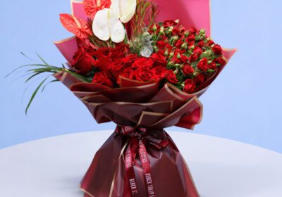 Bright and cheerful bouquet with red roses and white anthuriums.