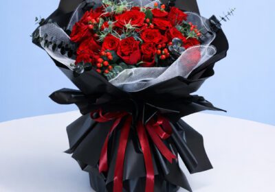 Romantic red roses in a dark wrapped bouquet, perfect for a special occasion.