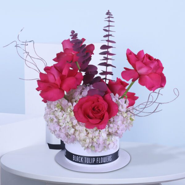 Pink rose arrangement with baby’s breath and foliage in a stylish floral box.