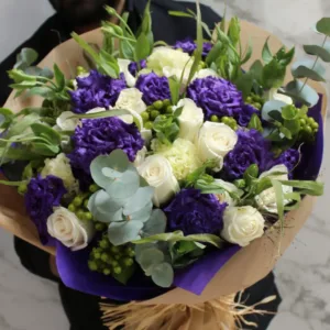 Deep purple mix with creamy white roses bouquet. This consists of Eustomas, Hypericum Berries, Roses, and Mix Foilage.
