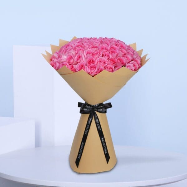 Blush Pink Rose – Revival 1 A bouquet of pink roses arranged in a rustic brown paper bag.