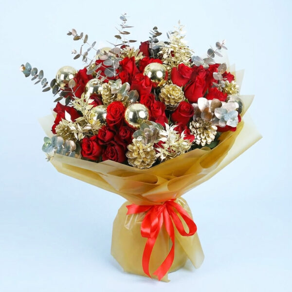 Christmas bouquet with red roses, gold pinecones, golden ornaments, and with festive wrapping
