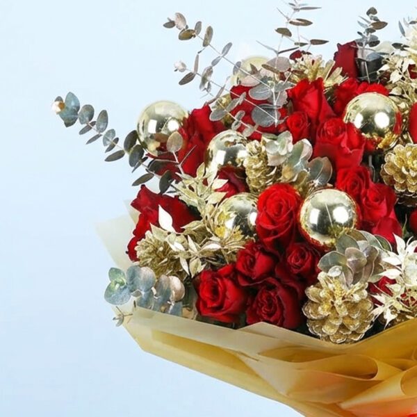 Christmas bouquet with red roses, gold pinecones, golden ornaments, and with festive wrapping