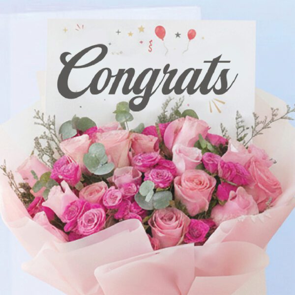 02 Bouquet featuring hand-tied pink roses, hot pink spray roses & eucalyptus in blush wrap, finished with a “Congrats” card.