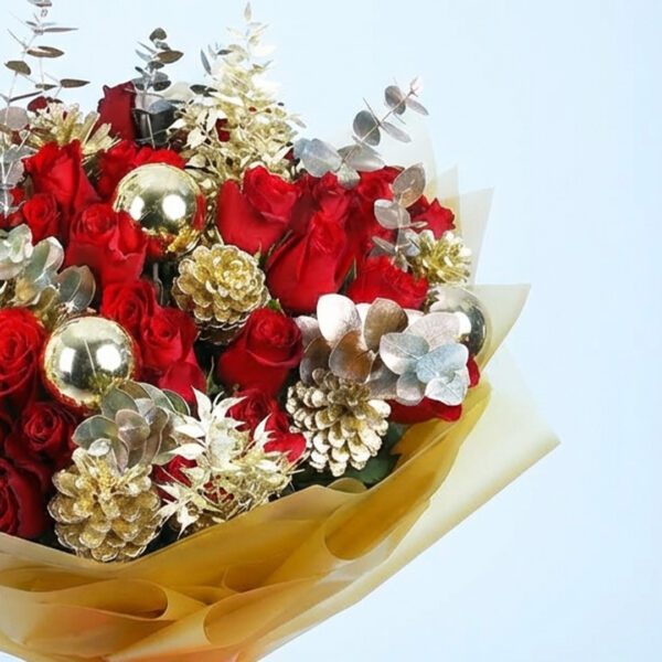 Christmas bouquet with red roses, gold pinecones, golden ornaments, and with festive wrapping